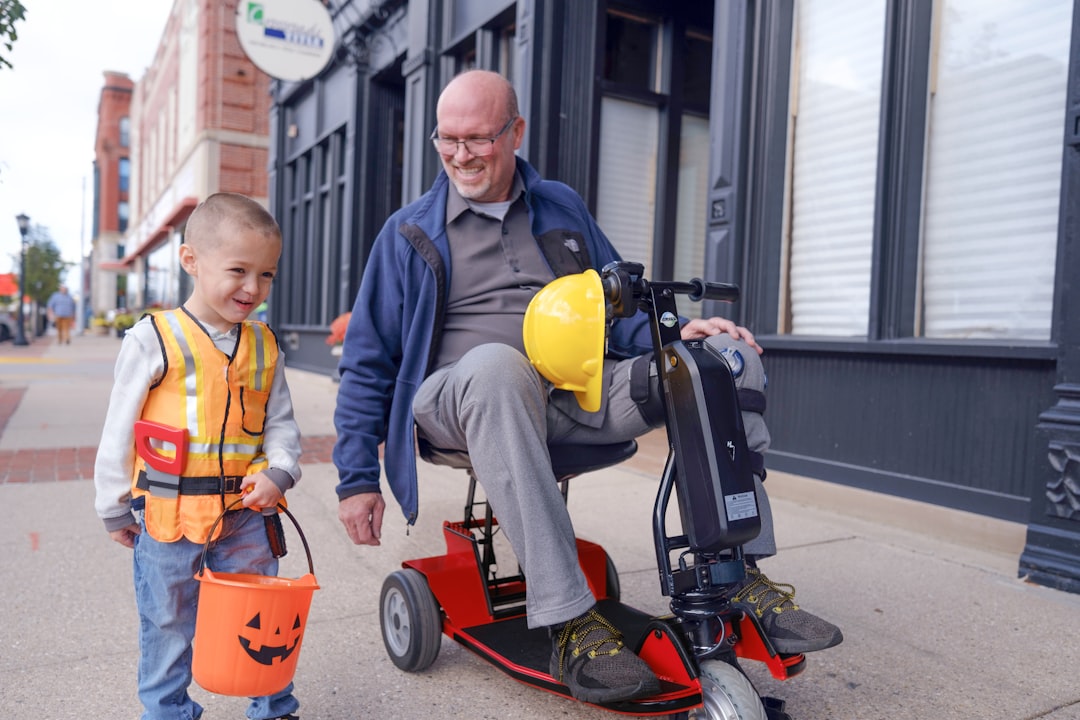 an-older-man-and-a-young-boy-on-a-scooter-sil5bnlmzfg